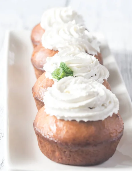 Baba au rhum op de plaat gerangschikt in een rij — Stockfoto