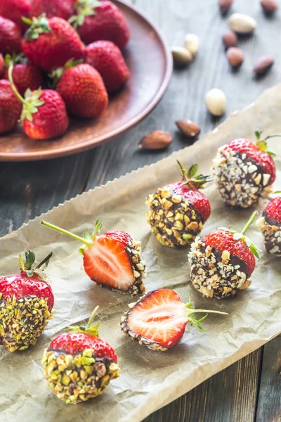 Fresh strawberries covered with dark chocolate and nuts