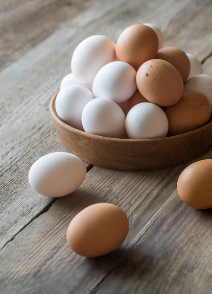 Wooden bowl of raw chicken eggs — Stock Photo, Image