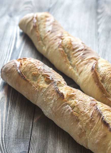 Due baguette sullo sfondo di legno — Foto Stock