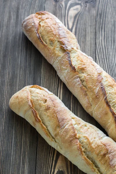 Due baguette sullo sfondo di legno — Foto Stock