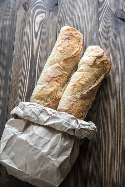 Due baguette sullo sfondo di legno — Foto Stock