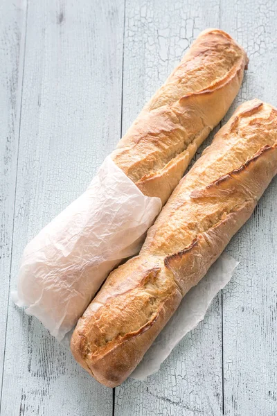 Due baguette sullo sfondo di legno — Foto Stock