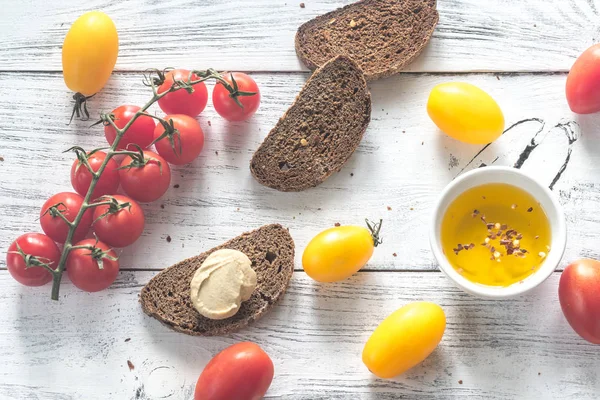 Fresh tomatoes with slices of dark-rye bread — Stock Photo, Image