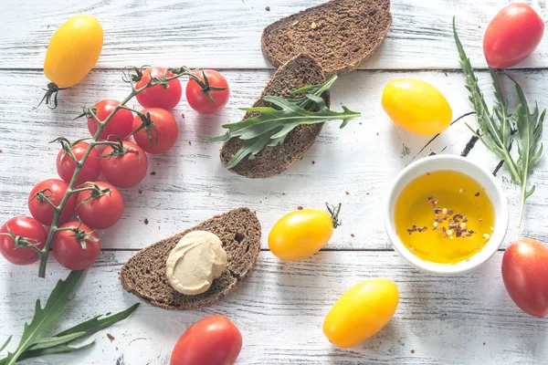 Ferske tomater med skiver av mørkt rugbrød – stockfoto