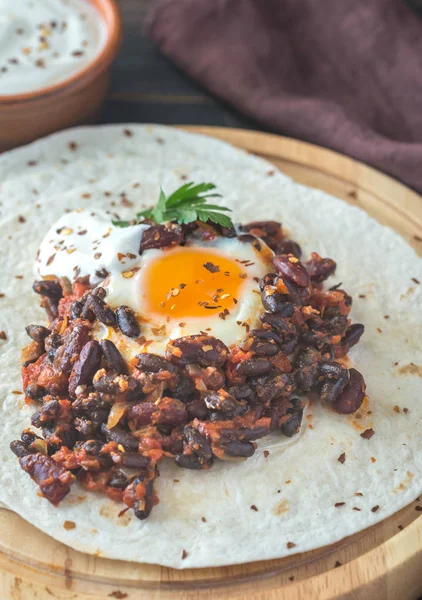 Tortilla with chipotle bean chili and baked egg — Stock Photo, Image