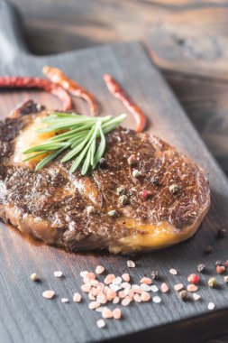 Ahşap tahta üzerinde taze biberiye ile sığır eti biftek