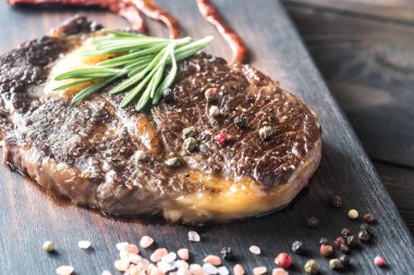 Ahşap tahta üzerinde taze biberiye ile sığır eti biftek