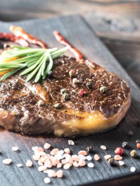 Ahşap tahta üzerinde taze biberiye ile sığır eti biftek