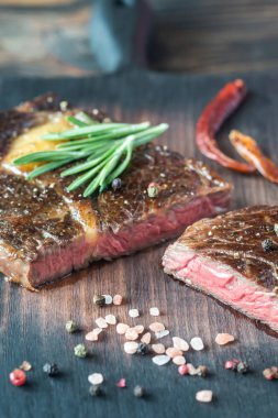 Ahşap tahta üzerinde taze biberiye ile sığır eti biftek