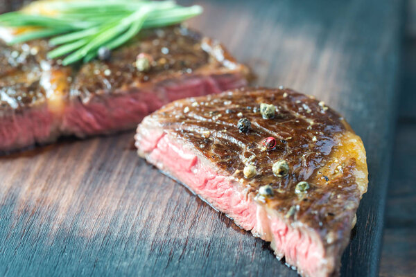 Beef steak with fresh rosemary on the wooden board
