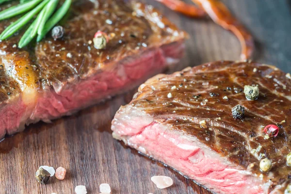 Ahşap tahta üzerinde taze biberiye ile sığır eti biftek — Stok fotoğraf