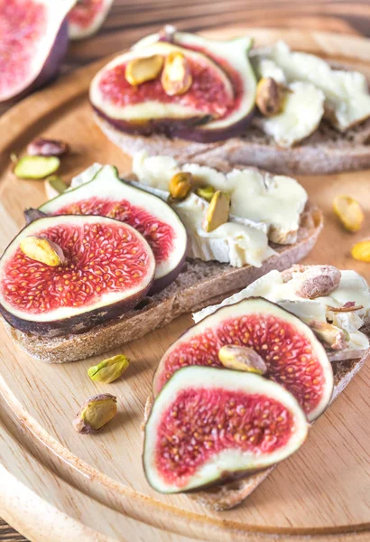 Slices of bread with camembert, figs and pistachios — Stock Photo, Image