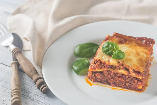 Portion of lasagne on the wooden table — Stock Photo, Image