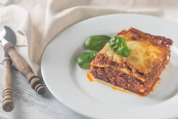 Portion of lasagne on the wooden table — Stock Photo, Image