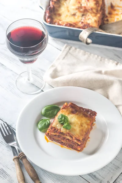 Gedeelte van lasagne met een glas wijn — Stockfoto