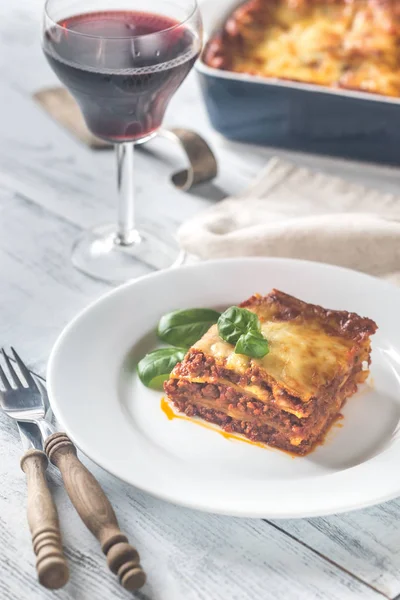 Portion Lasagne mit einem Glas Wein — Stockfoto