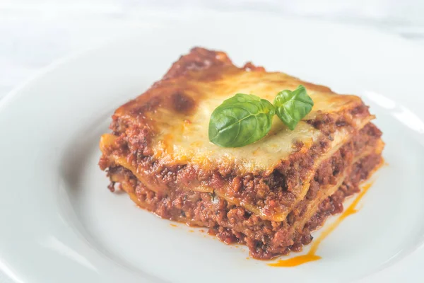 Część lasagne na drewnianym stole — Zdjęcie stockowe