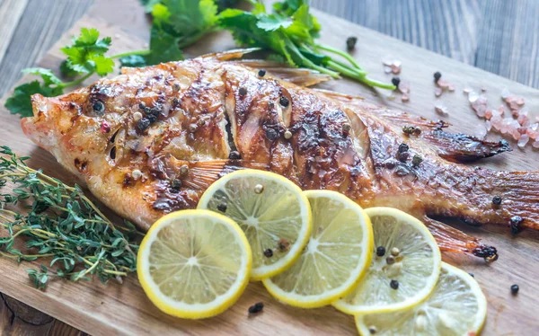 Grilled Tilapia with herbs on the wooden board — Stock Photo, Image