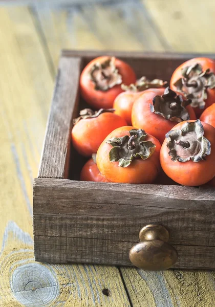 Wooden box of fresh persimmons — Stock Photo, Image