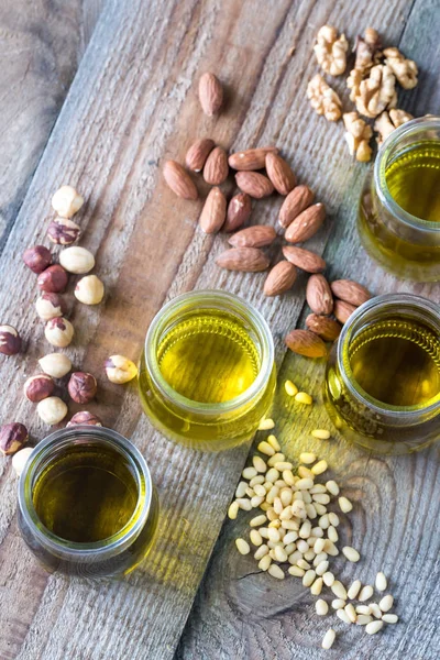 Glass jars with different kinds of nut oil — Stock Photo, Image