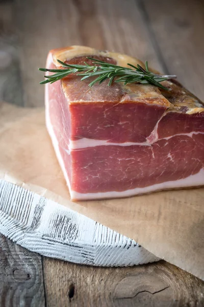 Prosciutto with fresh rosemary on the wooden board — Stock Photo, Image