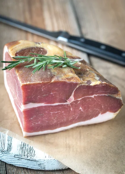 Prosciutto with fresh rosemary on the wooden board — Stock Photo, Image