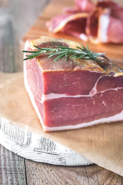 Prosciutto with fresh rosemary on the wooden board — Stock Photo, Image