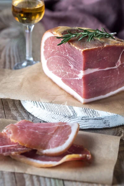 Prosciutto with fresh rosemary on the wooden board — Stock Photo, Image