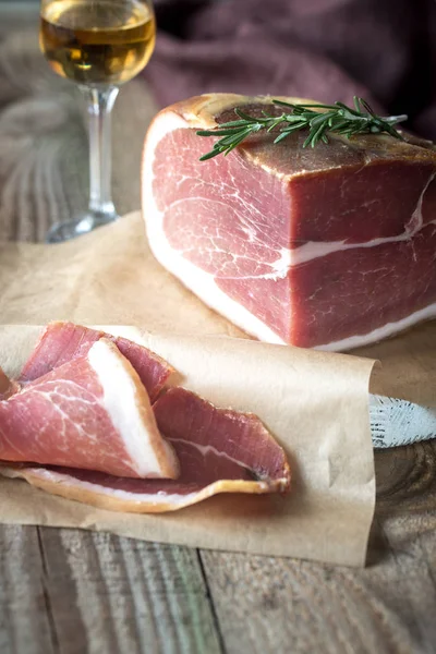 Prosciutto with fresh rosemary on the wooden board — Stock Photo, Image