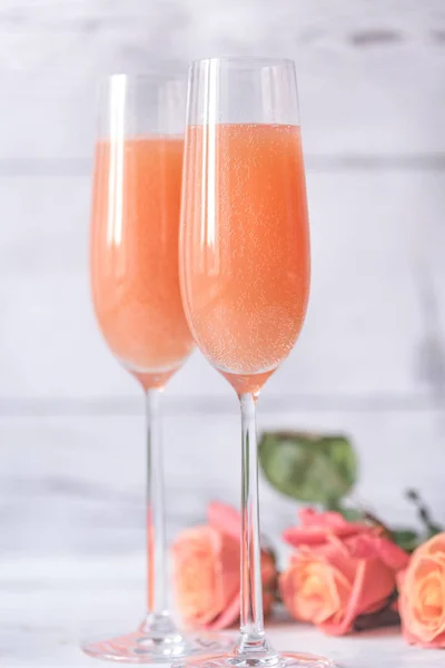 Två glas bellini cocktail med bukett rosor — Stockfoto