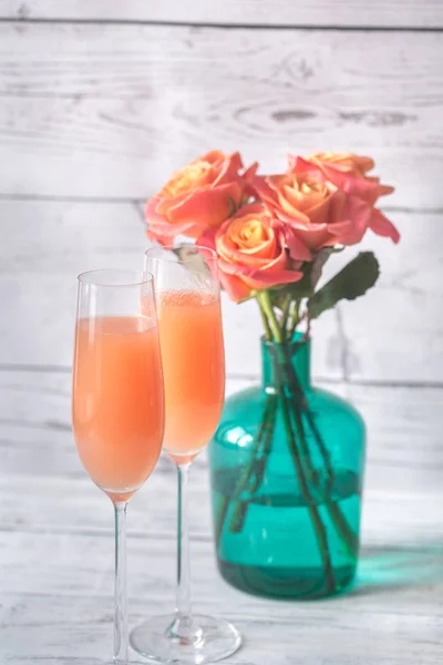 Två glas bellini cocktail med bukett rosor — Stockfoto