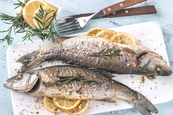 Baked sea bass with lemon and rosemary — Stock Photo, Image