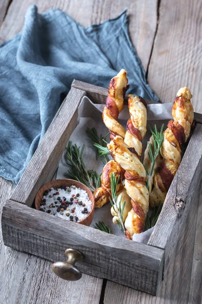 Spek gewikkeld breadsticks op de houten lade — Stockfoto