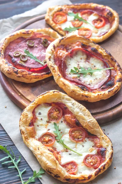 Mini pizzas na placa de madeira — Fotografia de Stock