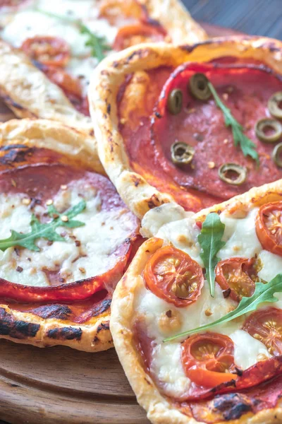 Mini pizzas na placa de madeira — Fotografia de Stock