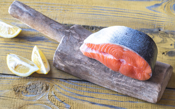 Стейк из сырого лосося на деревянной доске
