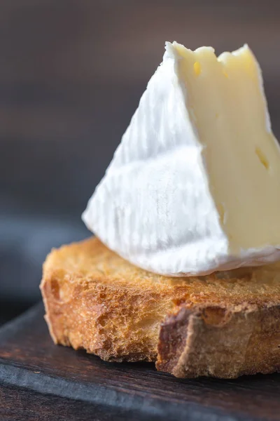 Torrada com queijo Camembert na tábua de madeira — Fotografia de Stock