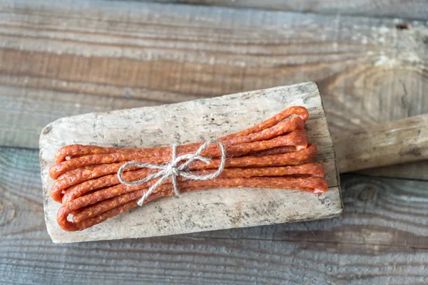 Smoked sausages on the wooden background — Stock Photo, Image