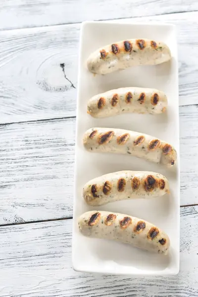 Salsichas grelhadas no prato branco — Fotografia de Stock
