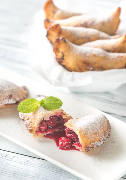 Empanadas de cereza en el plato blanco —  Fotos de Stock