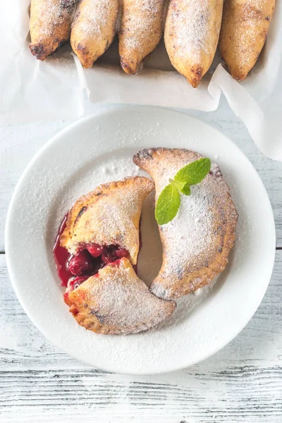 Empanadas de cereza en el plato blanco — Foto de Stock