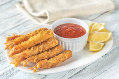 Tabağında sos olan karides tempura.