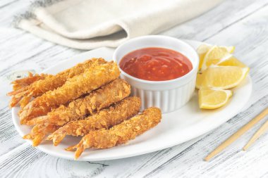 Tabağında sos olan karides tempura.