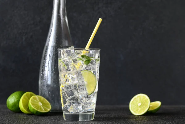 Glass of sparkling water with ice cubes and slice of lime — 스톡 사진