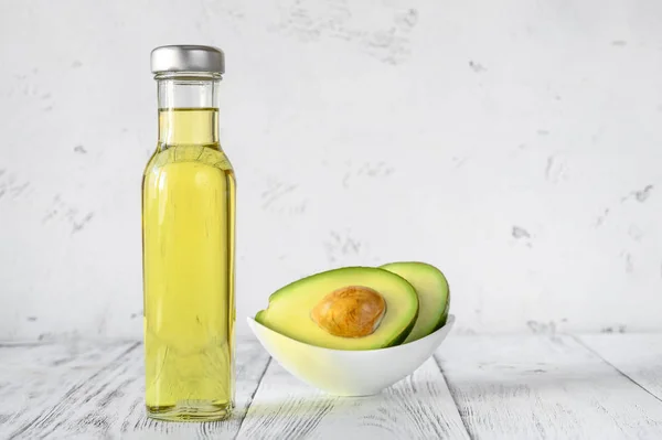 Bottle of avocado oil with fresh avocado — Stock Photo, Image