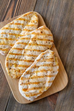 Grilled chicken on cutting board: top view