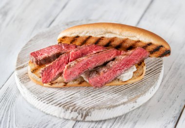 Tahtada dilimlenmiş biftek ve ricotta ile sandviç.