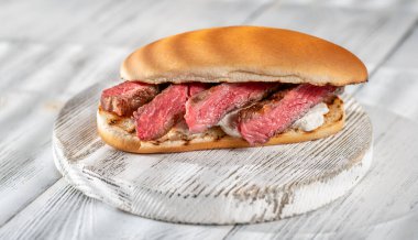 Tahtada dilimlenmiş biftek ve ricotta ile sandviç.