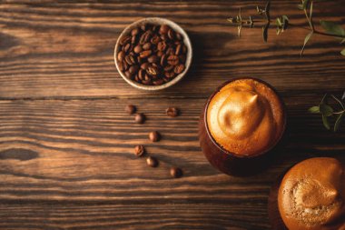 Yumuşak kremşantili kahve, dalgona kahve, meşrubatlı klasik tahta bardaklar, moda Kore içeceği, üst manzara, kopyalama alanı